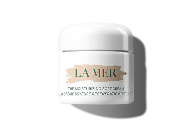 La Mer moisturizing soft cream jar with beige brushstroke label and teal text, casting a shadow on a white background