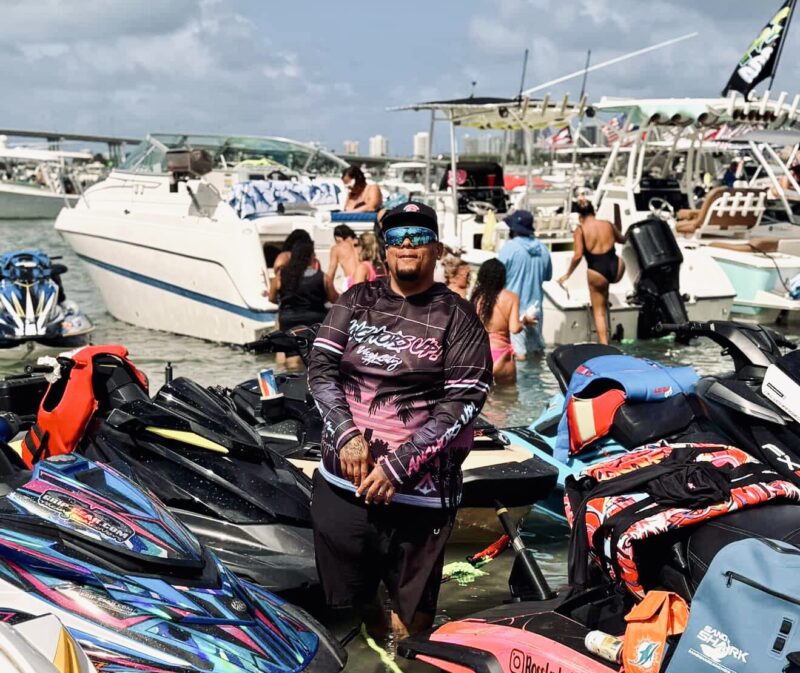 Rico Goyochea, SeaDoo RXT-X 325 rider and WavesRX team member, poses among jet skis at a Miami sandbar.