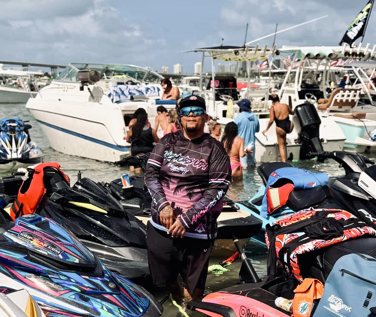 Rico Goyochea, SeaDoo RXT-X 325 rider and WavesRX team member, poses among jet skis at a Miami sandbar.