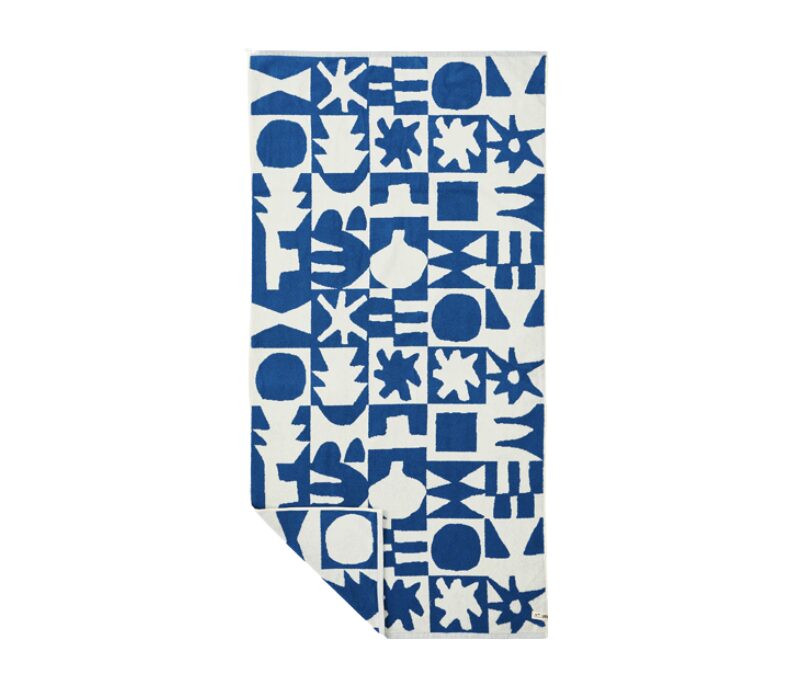 Blue and white towel with a bold geometric abstract pattern folded with a corner showing