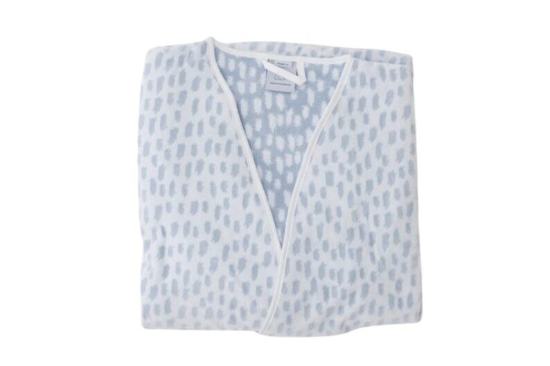Light blue patterned bathrobe folded neatly with white trim and V-neck wrap