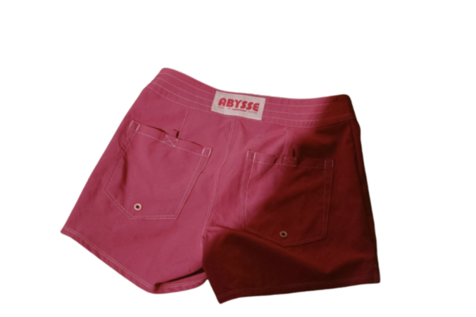 Abysse - The Wake Edit Back view of two-tone pink shorts with white stitching and two back pockets; ABYSSE brand label on waistband.