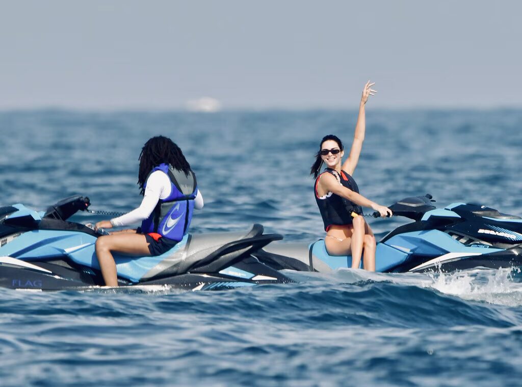 Two people riding blue jet skis on the ocean, one of the most iconic celebrity jet ski looks