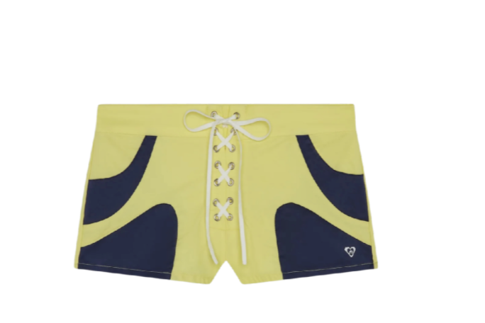 Miaou - The Wake Edit Yellow swim shorts with navy curved side panels and a white lace-up front, flat lay with a small logo on the lower right.